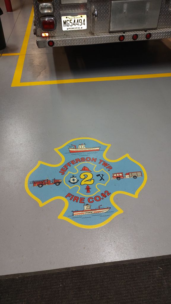 Fire station grey epoxy floor with lines and custom logo closeup, Jefferson Twp, NJ